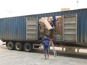 Công nhân đang bốc xếp các thùng carton hàng hóa lên xe tải chuyên dụng.