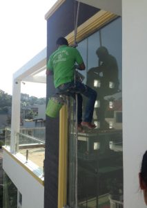 Công nhân đu dây lau kính mặt ngoài tòa nhà cao tầng chuyên nghiệp tại Hạ Long.