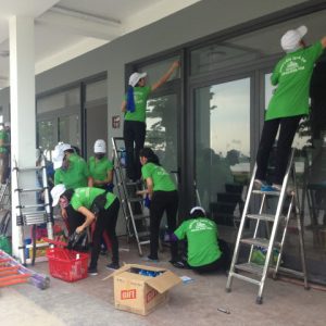 Đội ngũ công nhân Nhà sạch Hạ Long 24h đang đứng trên thang thi công vệ sinh công nghiệp lau kính mặt ngoài.